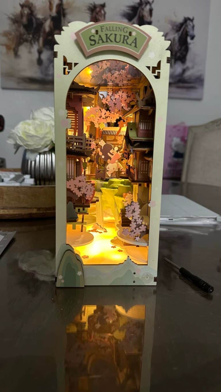 Boîte à lumière japonaise avec cerisiers en fleurs, détails en bois, ambiance chaleureuse.